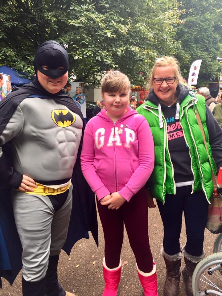 Batman Poses for a photo with a young girl and her mum